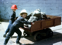 Two children pushing a copper mine tram car